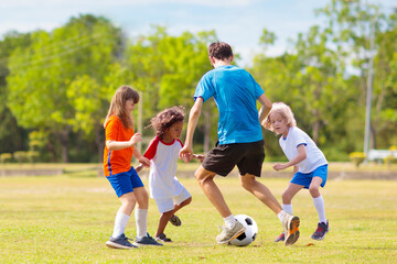 Kids play football. Child at soccer field.