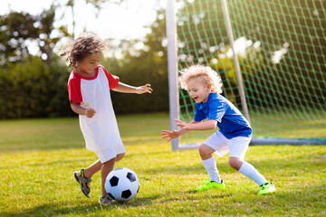 Kids play football. Child at soccer field.