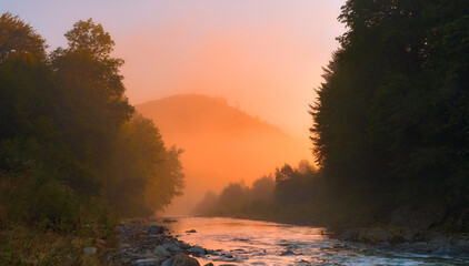 Fototapeta na wymiar Foggy dawn over a mountain river ..