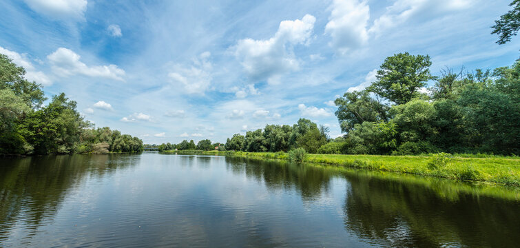 Panorama einer Flusslandschaft vom Wasser aus gesehen, viel Textfreiraum
