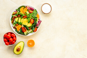Healthy vegetarian lanch with bowl of green salad with avocado and tomatoes