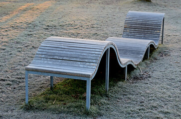 design bench in the shape of a wavy line. wooden paneling on a metal galvanized frame. The bench is...