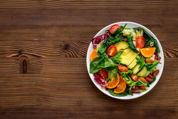 Bowl of green salad with avocado and tomatoes. Healthy vegetarian lanch