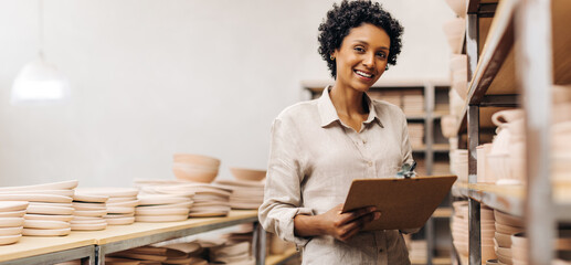 Happy ceramic shop owner smiling at the camera in her store