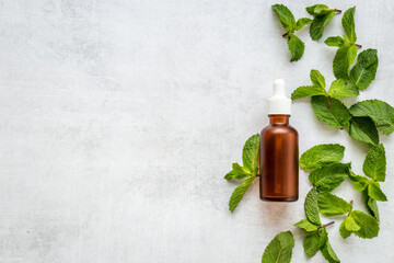 Peppermint essential oil in bottle with fresh mint leaves © 9dreamstudio