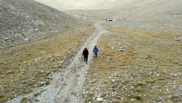 Drone Video following hikers walking Mountain trail Olympus Greece moving back e4