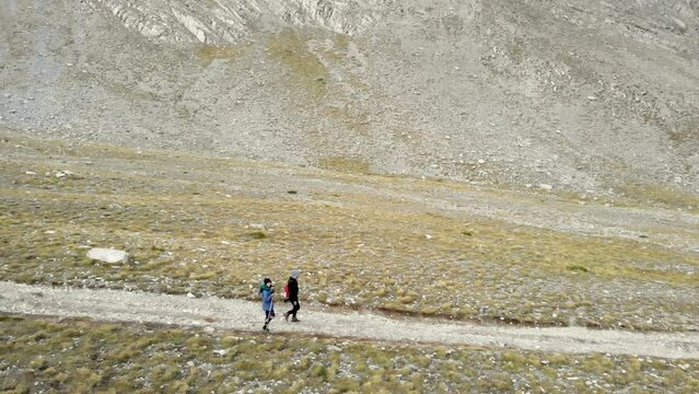 Drone Video couple hikers walking Mountain trail Olympus Greece panning right e4