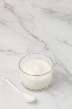 Creamy natural yogurt on a light background, Probiotic cold fermented dairy drink. vertical image. top view. place for text