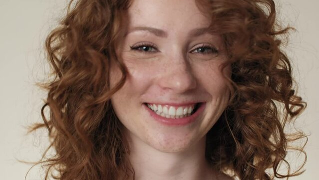 Cheerful caucasian red head woman making funny faces in the studio. Shot with RED helium camera in 8K. 