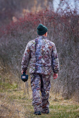 Professional wild life photographer in camouflage clothing in nature