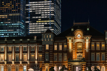 日本　東京都千代田区丸の内のライトアップされた赤レンガ作りの東京駅舎と高層ビル群の夜景