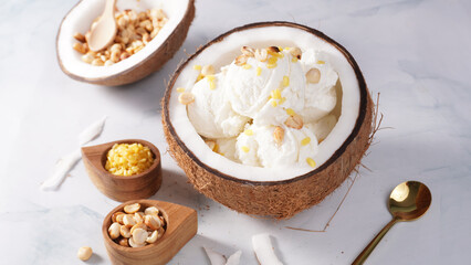 Coconut ice cream topped with roasted peanuts in a coconut shell macro shot. (spot focus)