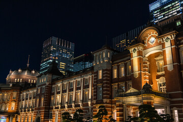 日本　東京都千代田区丸の内のライトアップされた赤レンガ作りの東京駅舎と高層ビル群の夜景
