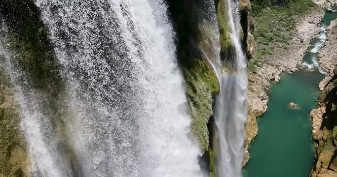 Aerial View Big Tamul Waterfall drone tilts down to show water falling with Rainbow in San Luis Potosi Mexico