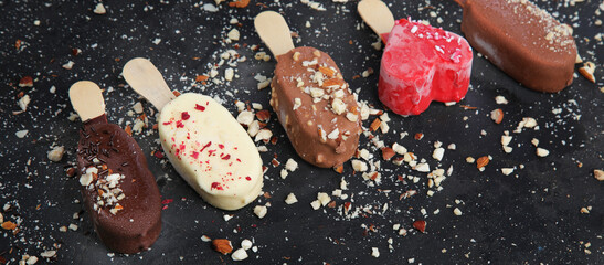 Popsicle ice-cream assortment on dark background.
