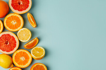 top view of orange grapefour and lemon citrus fruits with  herbs on blue background