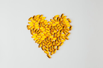 top view of omega fish oil pills laid out in heart shape on white background