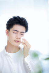 コットンでお肌を整える美しい男性のイメージ