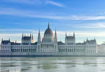 The Budapest Parliament building at a foggy morning with the Danube in the foreground