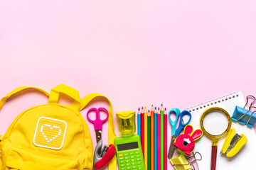 Back to school, education concept Yellow backpack with school supplies - notebook, pens, eraser rainbow isolated on pink background Top view Copy space Flat lay composition Banner