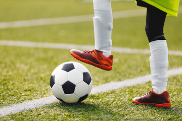 Youth Football Background. Young Boy Wearing Soccer Cleats, Socks and Soccer Pants. Kid Kicking...