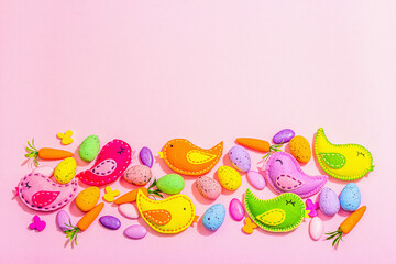 Handmade Easter background with colorful felt birds. Decorative eggs and sweet candies, cute rabbit