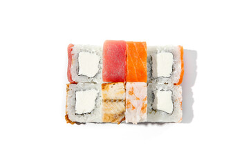 Assorted maki sushi with salmon, tuna, eel and shrimp on white background. Mix sushi rolls with fish and seafood in minimal style. Simple maki  with cheese inside salmon, tuna, prawns and eel outside.