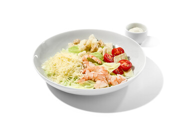 Classic italian food - caesar salad with shrimps on white plate in minimal style. Caesar salad with shrimp isolation on white background. Simple food. Italian salad with prawns.