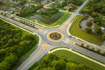 Aerial view of road roundabout intersection with moving cars traffic. Rural circular transportation...