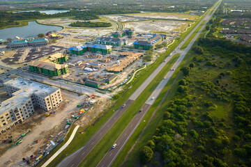 Aerial view of unfinished frames of apartment buildings close to local transportation artery under...