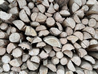 Natural wooden background. Firewood stacked and prepared for winter Pile of wood logs. Wooden natural sawn logs as background