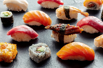 Sushi. Rolls, maki, nigiri on a black background, Japanese food. Salmon, tuna, eel, shrimp and...