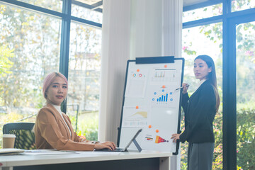 Two brunette business woman, talking, advising each other.