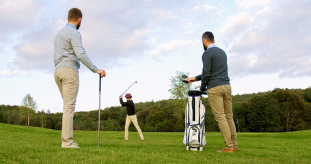 Background of handsome man playing golf on the pitch. His male friends with clubs watching on the...
