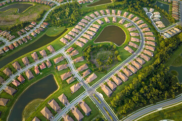 View from above of densely built residential houses near retention ponds in closed living clubs in...