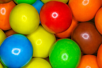 Fototapeta na wymiar Multi-colored spherical balls candies dragees in bulk close-up, full depth of field background wallpaper, uniform texture pattern