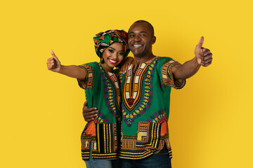 Obraz premium Cheery african husband and wife showing thumb ups