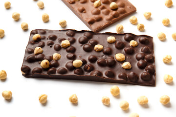 Black and milk chocolate with hazelnuts on a white background