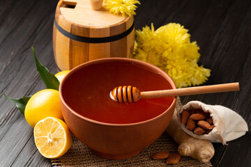 Clay bowl with honey and a wooden barrel for honey on a wooden background. Close-up.