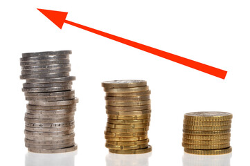 Concept de bénéfices avec des piles de pièces de monnaie et une flèche rouge sur fond blanc