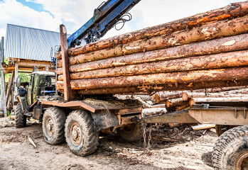 Timber carrier with sawn logs at the wood storage place