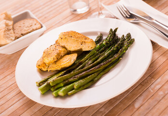 fried chicken breast pieces with asparagus on white plate