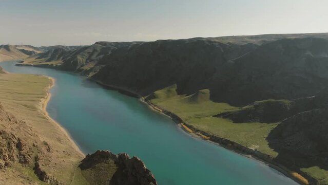 A beautiful turquoise river flowing through a deep canyon. Ili River in the spring. Kazakhstan. Almaty region