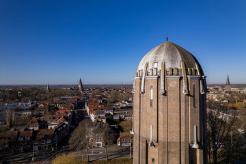 Top of the water tower in Zutphen rising above cityscape Hanseatic city against a clear blue sky seen from above. Aerial  architectural detail and historic engineering concept