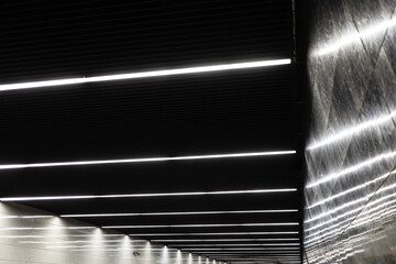 abstract illumination on black granite ceiling and walls of underground passage of metro station