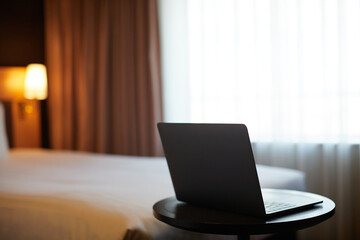 Fototapeta na wymiar ホテルの客室のベッドと開いたノートパソコンの様子