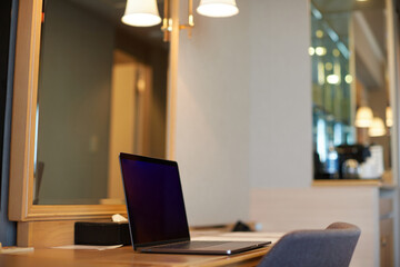 ホテルの客室の机と開いたノートパソコンの様子