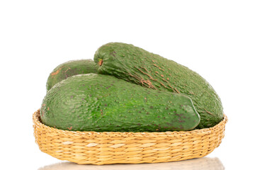 Three juicy avocados in a straw plate, macro, isolated on a white background.