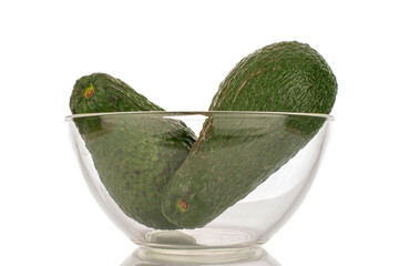 Two juicy avocados in a glass dish, macro, isolated on a white background.