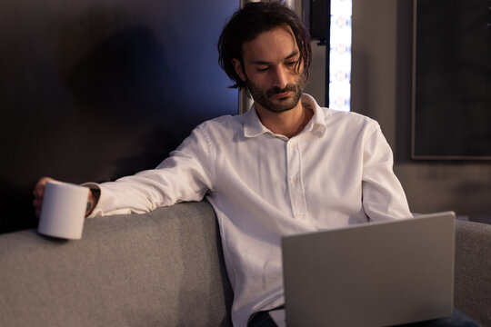 portrait d'un homme qui travaille sur son ordinateur portable, assis dans un sofa